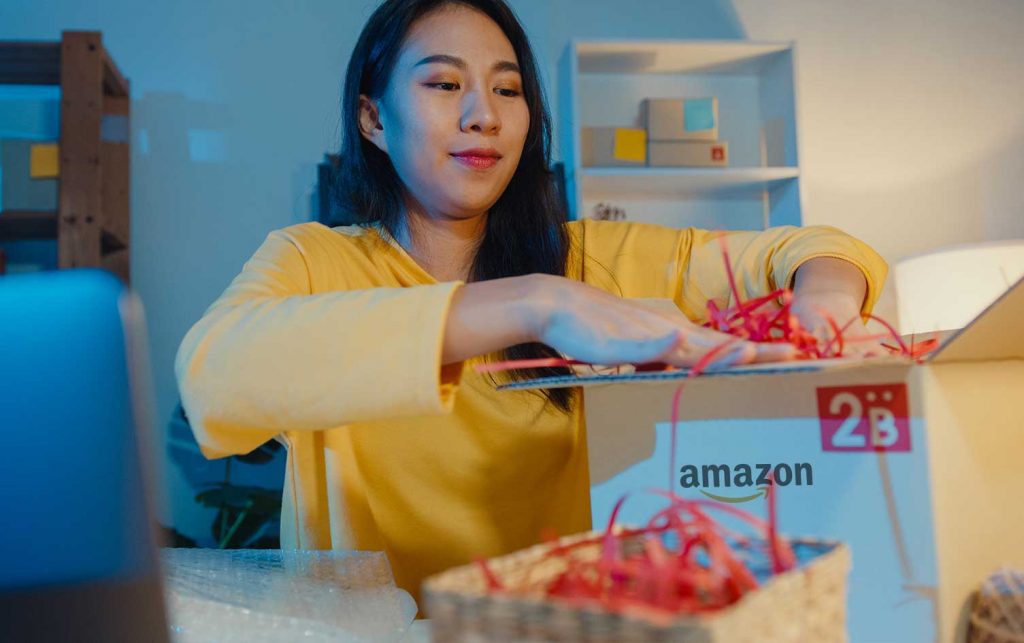 A woman is opening an amazon box in front of a laptop with my amazon guy.